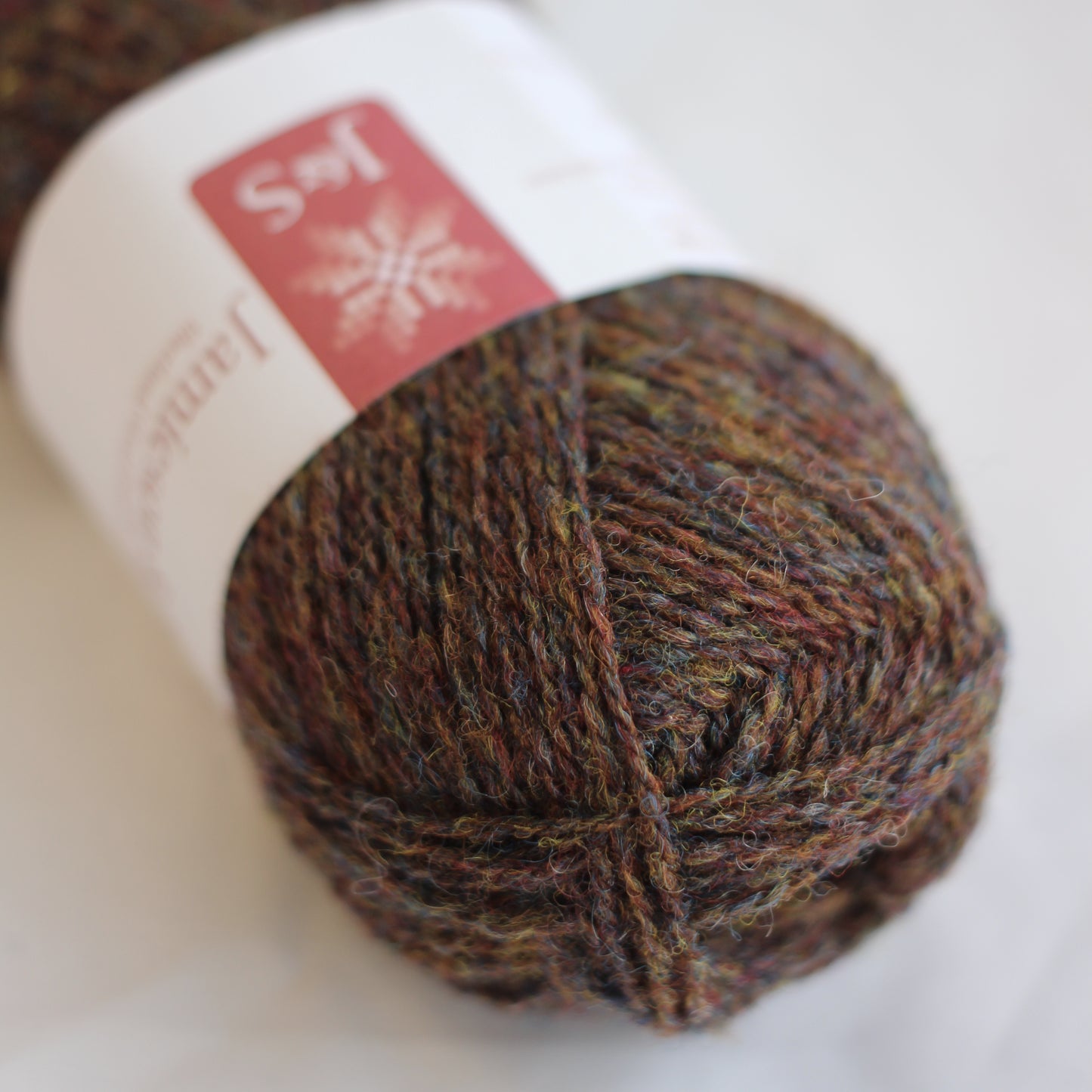 Ball of yarn with a brand label on a white background