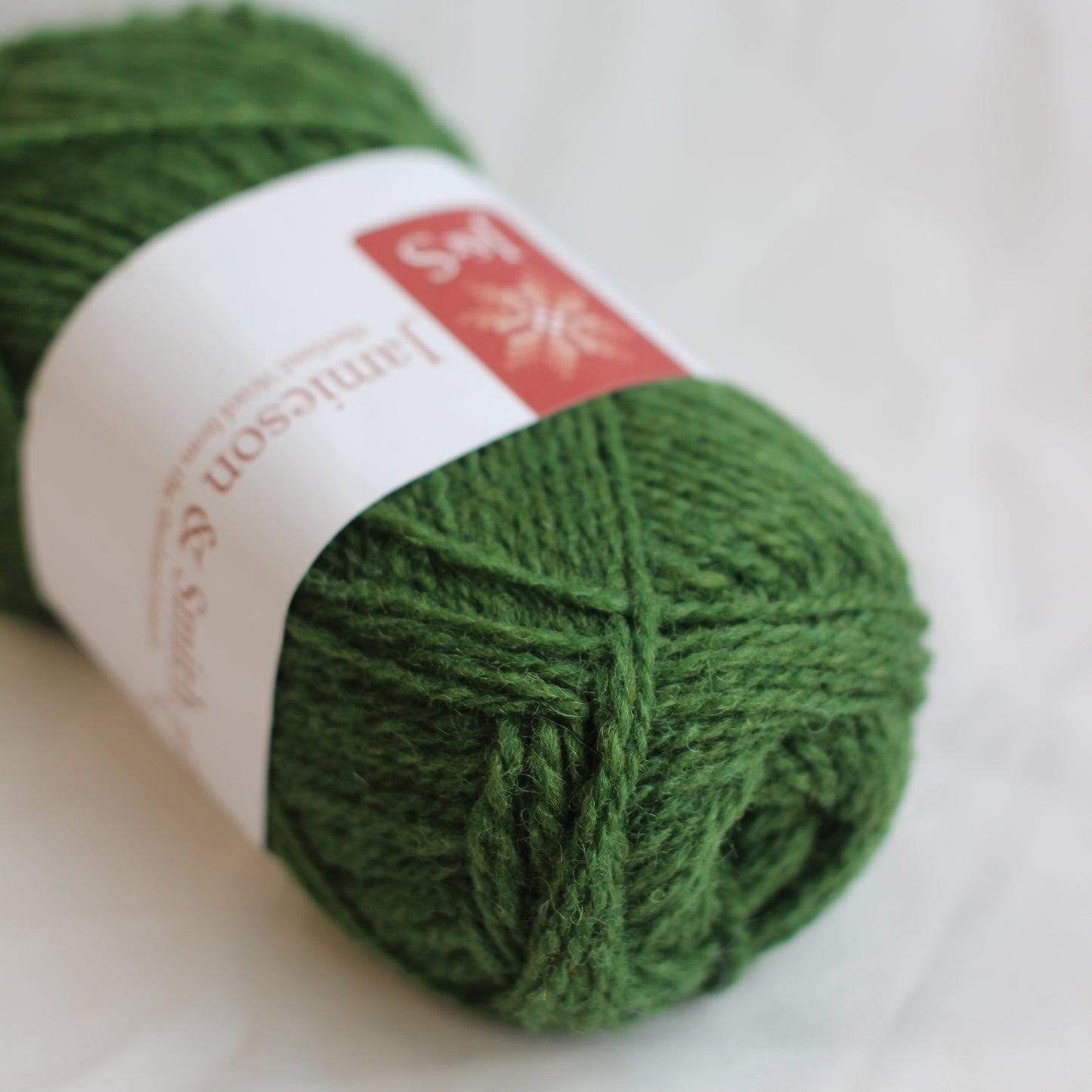 Green skein of yarn with a label on a white background