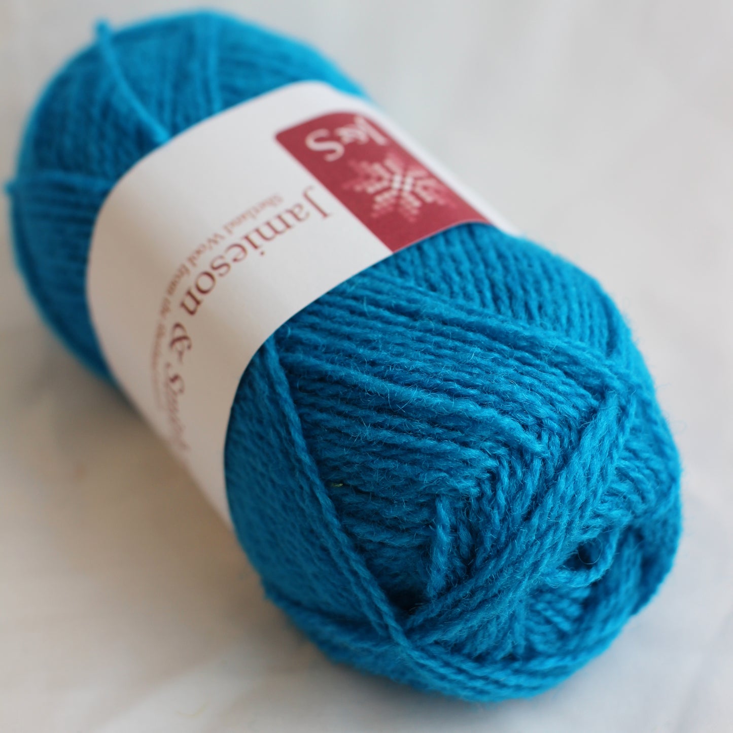 Blue yarn ball with a label on a light background