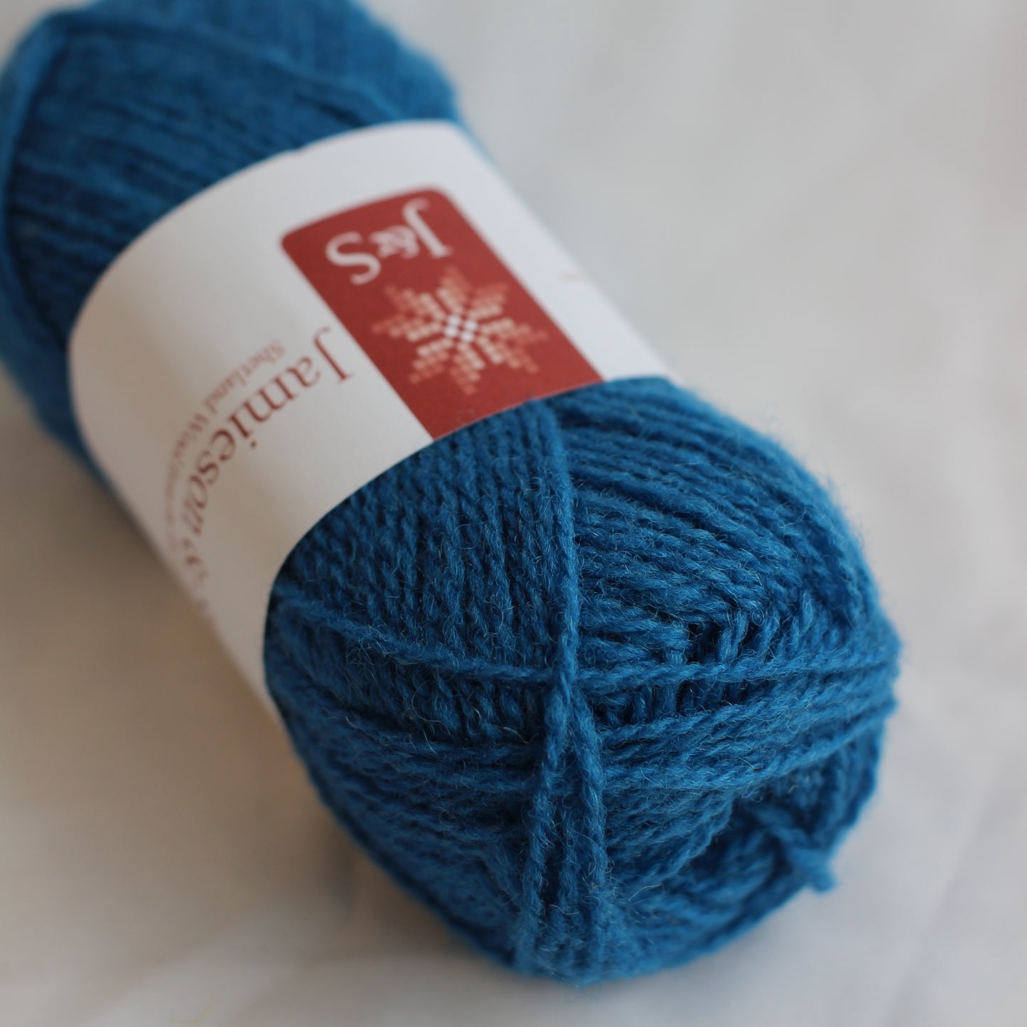 Blue yarn ball with a label on a light background