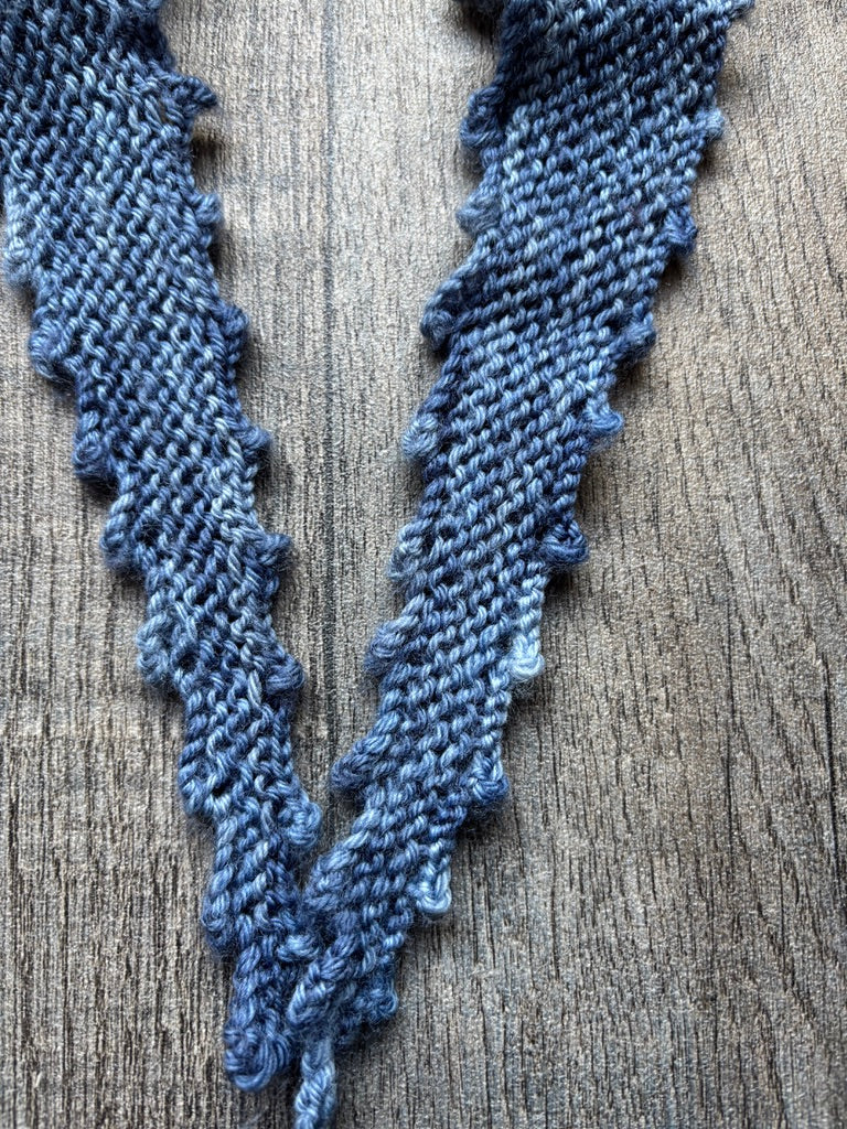 Single Skein Wrap - Pattern featuring a picot edged design, showcasing a delicate knit wrap on a wooden background.