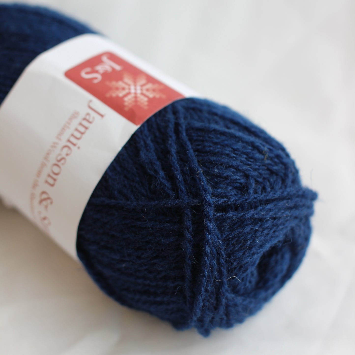 Ball of blue yarn with a label on a white background