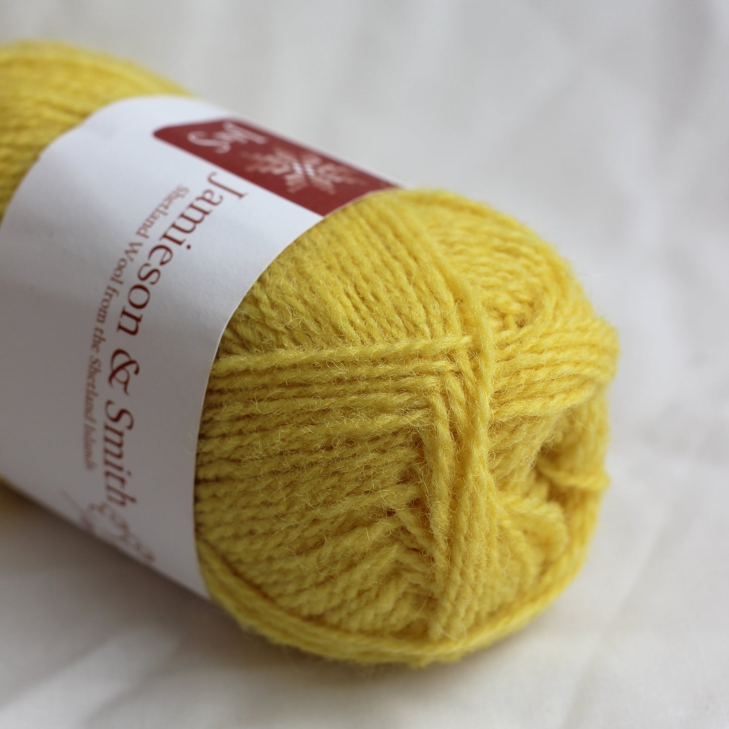 Yellow yarn ball with a label on a white background