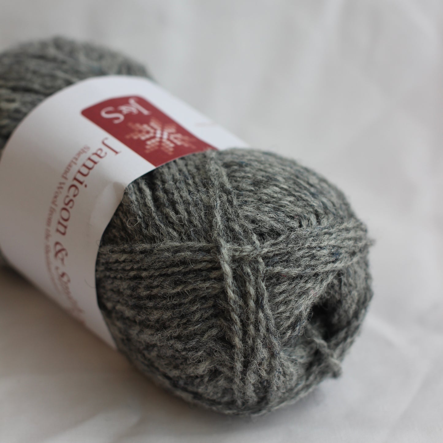 Gray yarn ball with a label on a white background