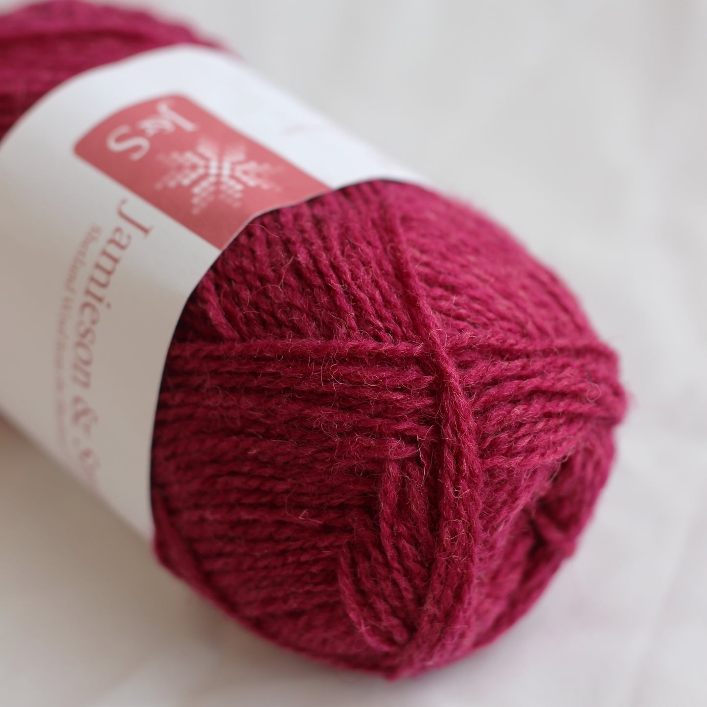 Ball of red yarn with a label on a light background