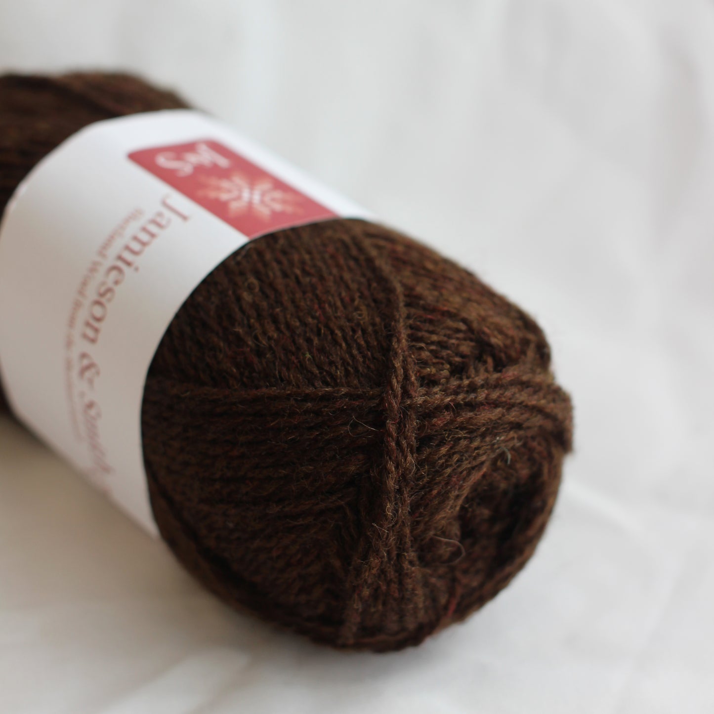 Brown yarn ball with a label on a white background