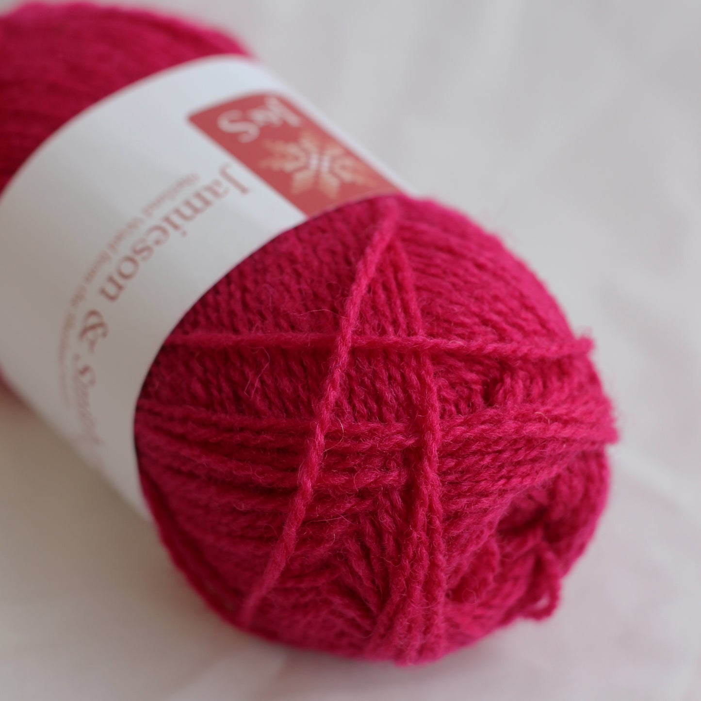 Red skein of yarn with a label on a white background