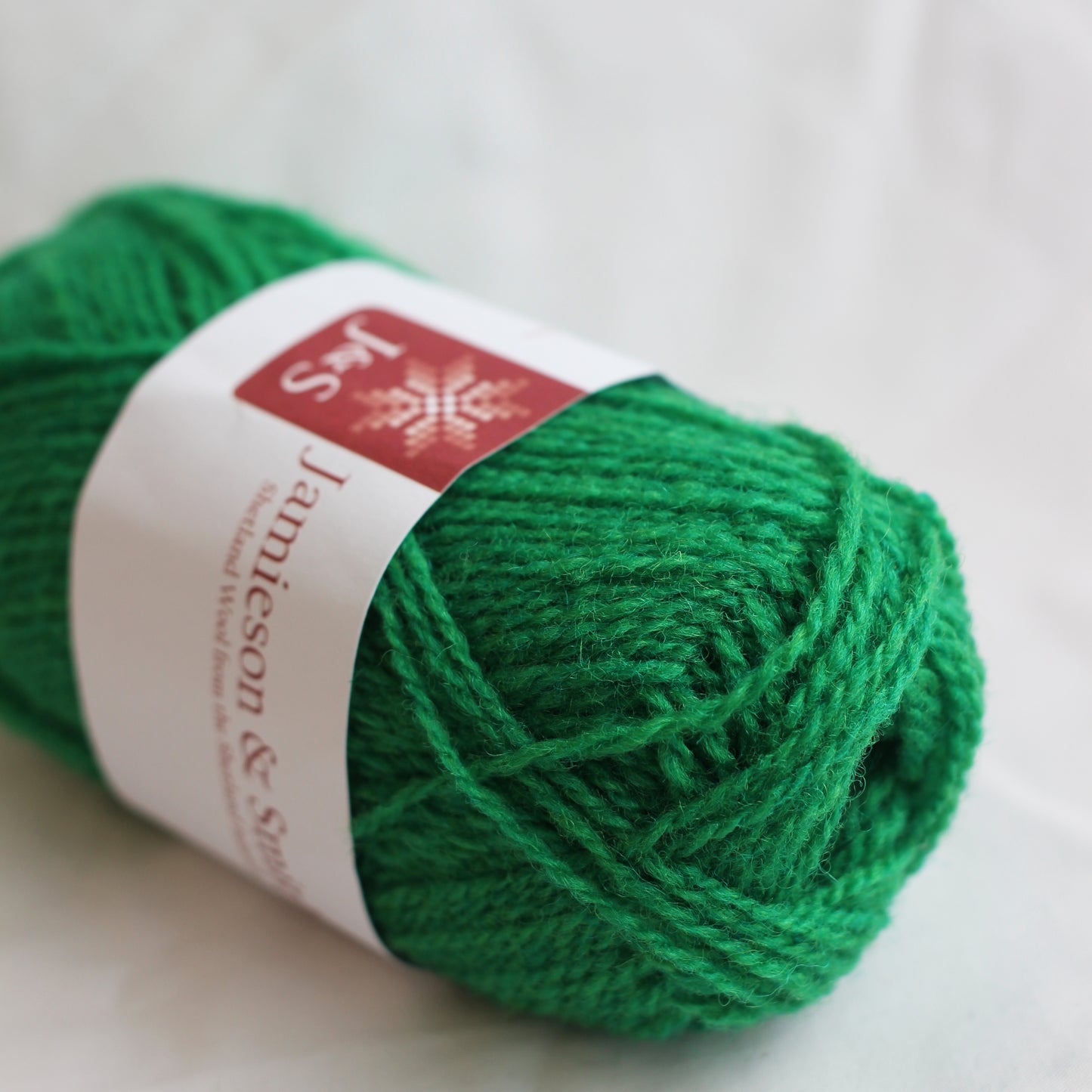 Green yarn ball with a label on a white background