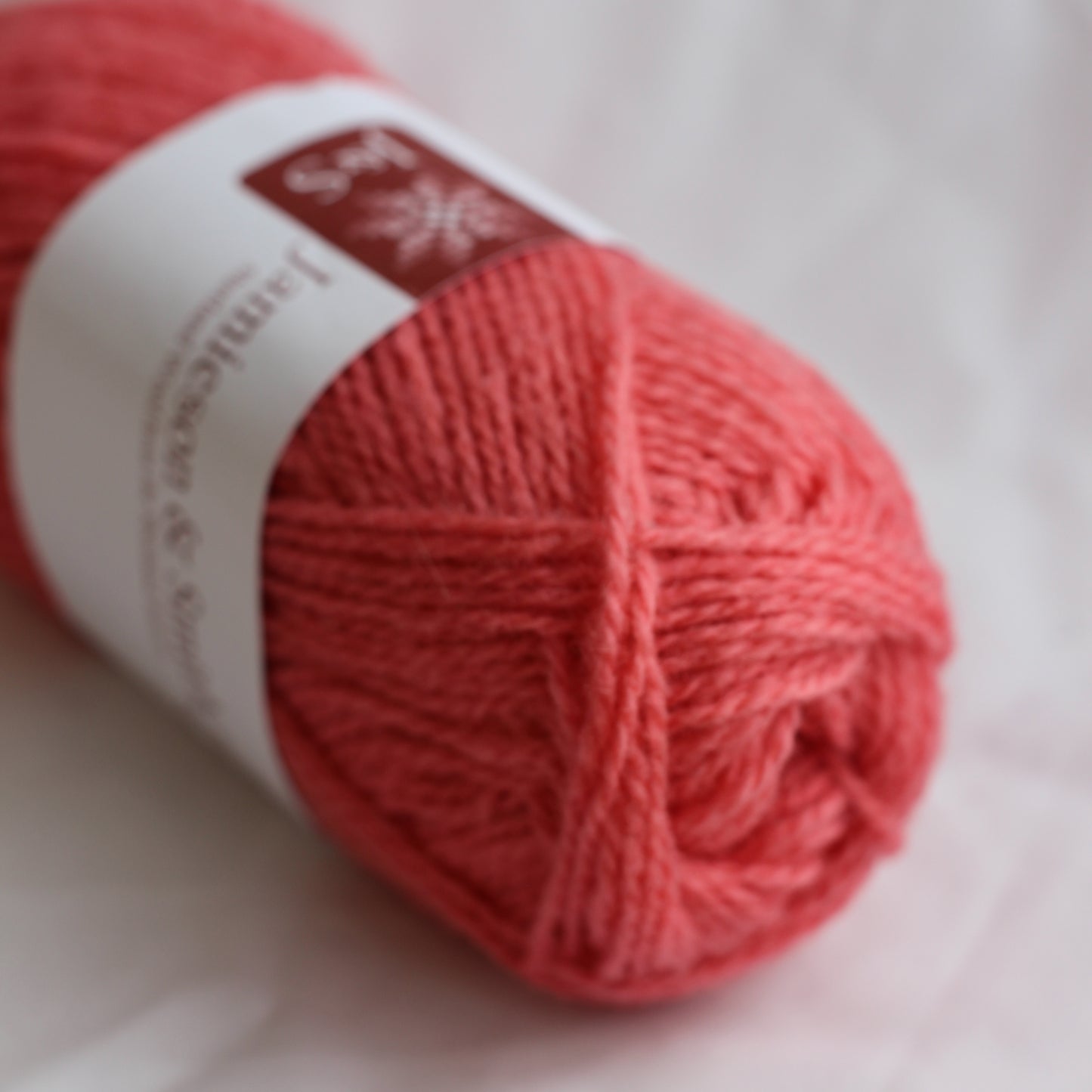 Ball of red yarn with a label on a white background