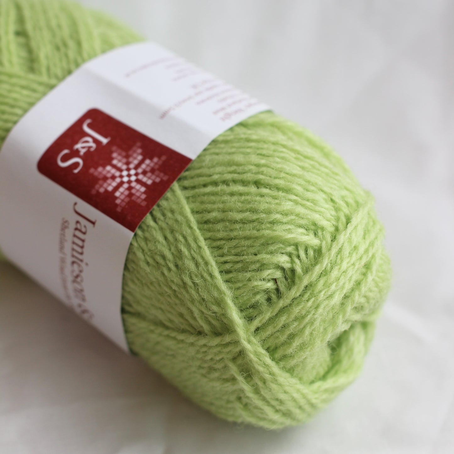 Green skein of yarn with a label on a white background