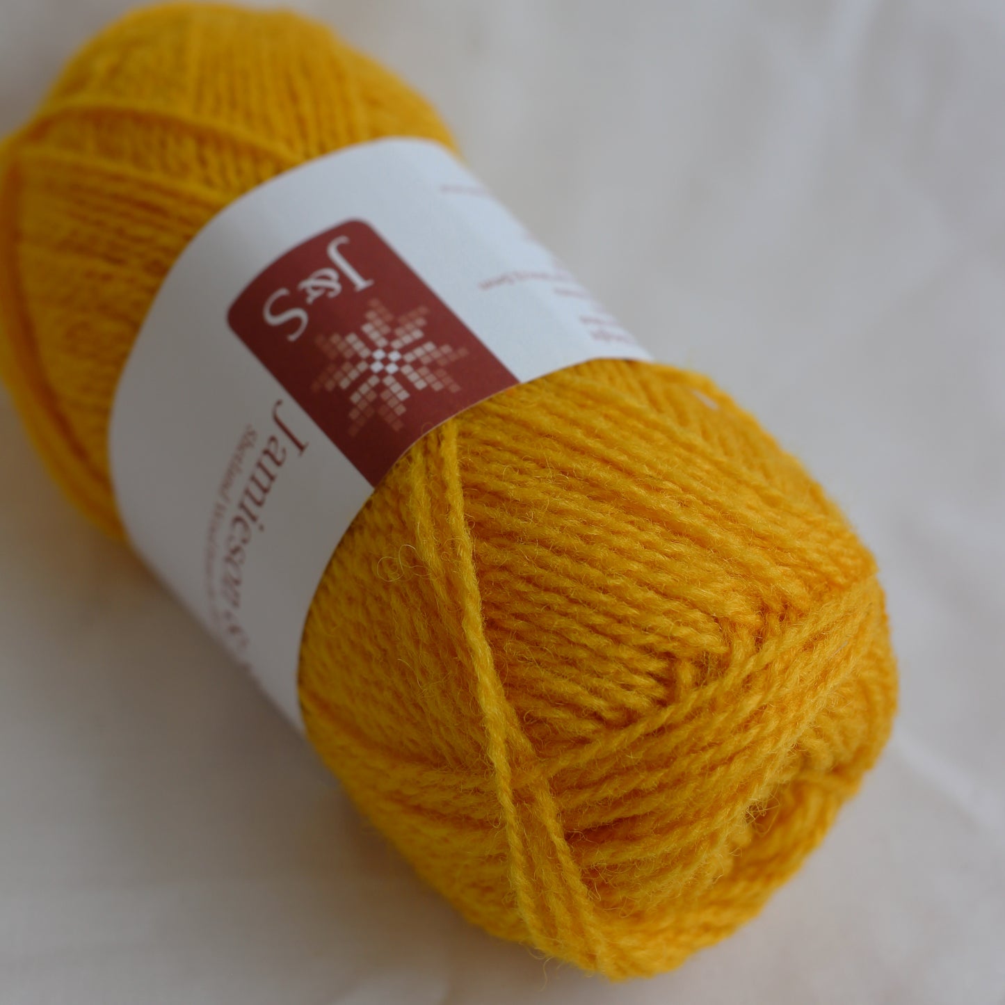 Yellow yarn ball with a label on a white background