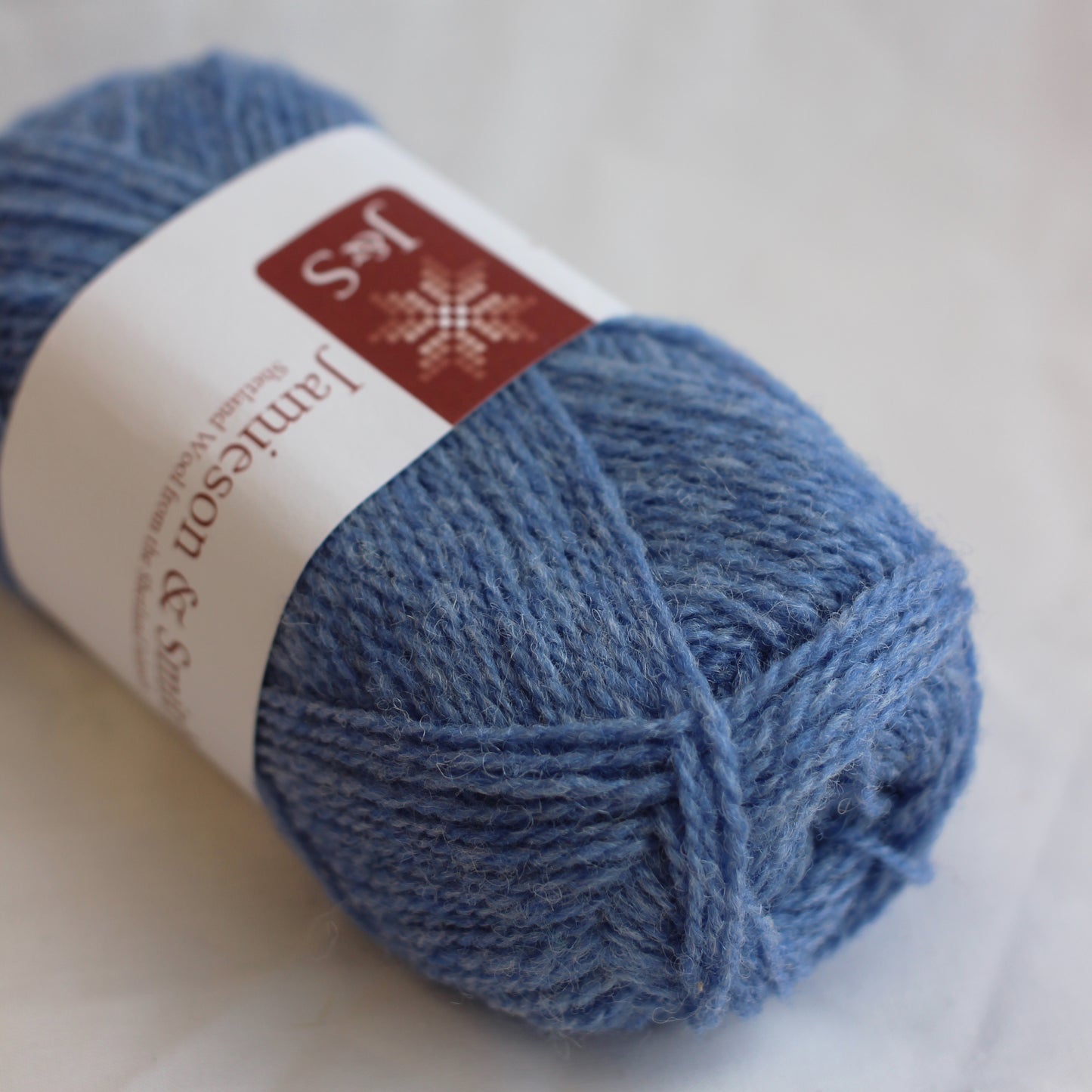 Blue yarn ball with Jamieson & Sons label on a light background